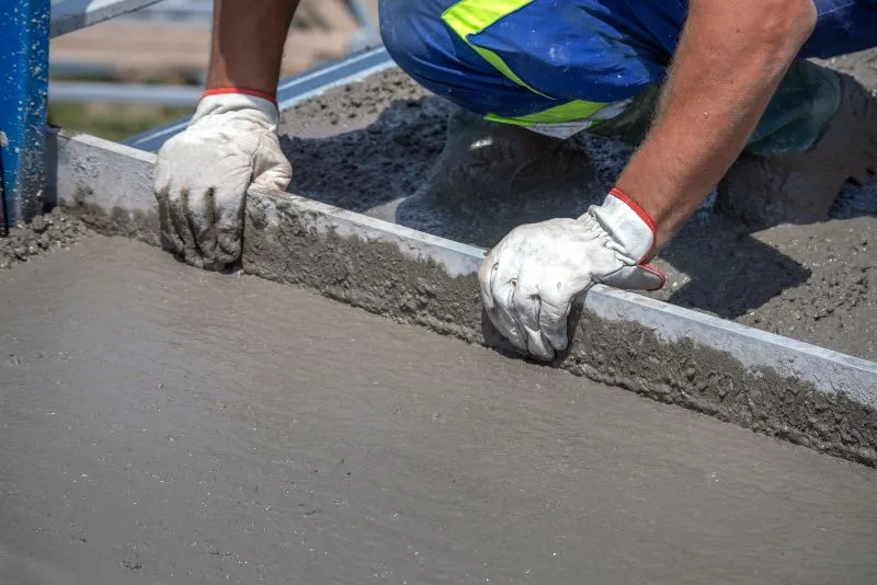 Concrete worker levelling a freshly poured slab at a Tweed Heads property